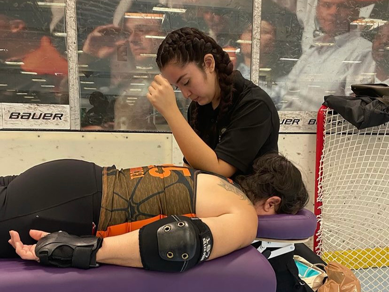 NHI Ontario Massage School graduate Alissa Chavez providing Sports Massage