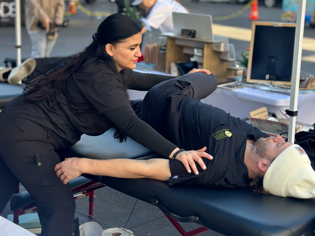 NHI Massage Therapy Student Stretching an Athlete at a Sports Massage Event
